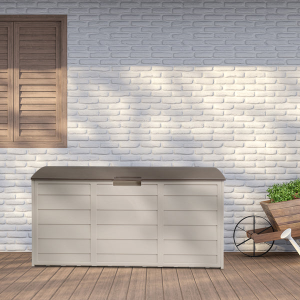 The deck box standing against a white brick wall on a wood deck