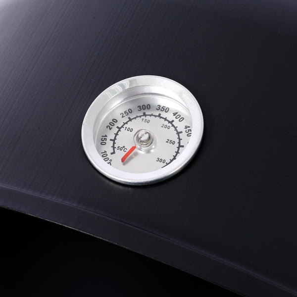 Close up of the round temperature gauge mounted on the smoker body