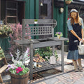 Gardener potting up plants at the bench