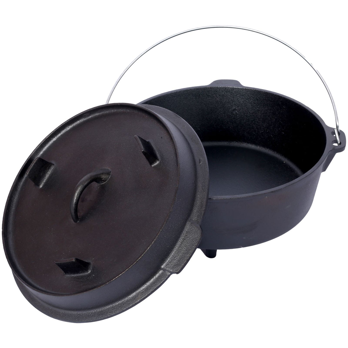 Black cast iron camp pot with its lid propped against the side and the wire bail handle raised