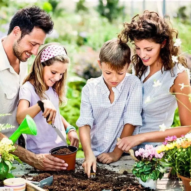 A family using the tools in a garden bed