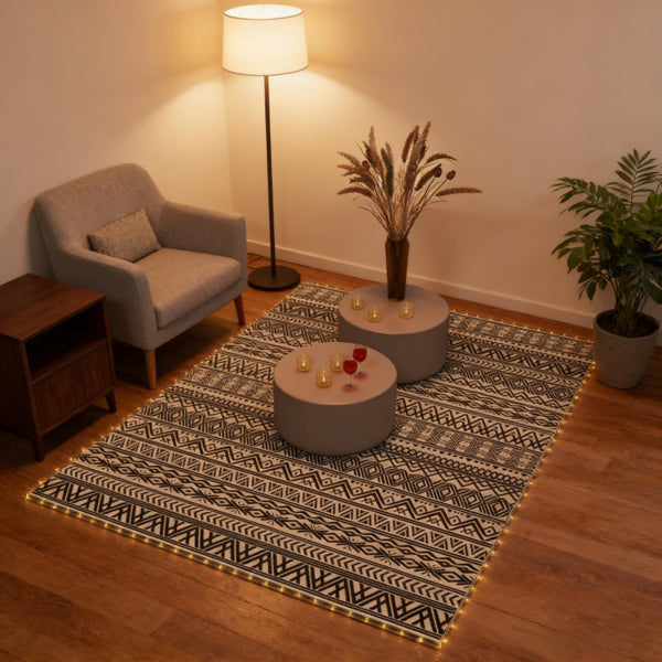 Black and cream patterned rug on a wood floor in a living room with an armchair and floor lamp
