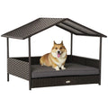 Dog resting on a wicker pet bed with a canopy