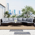 Half-moon rattan sofa set with gray cushions on a rooftop terrace