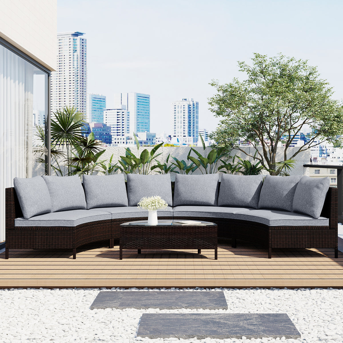 Half-moon rattan sofa set with gray cushions on a rooftop terrace