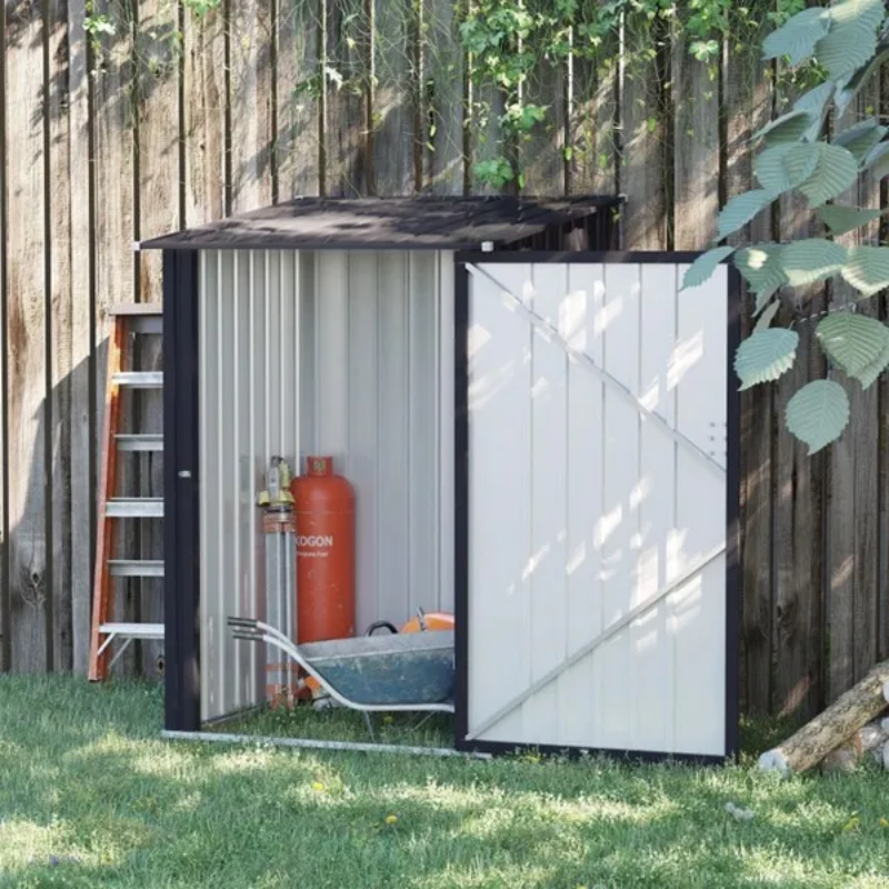 The shed on grass against a wooden fence with its door swung open, a stepladder, propane bottle and wheelbarrow stored inside