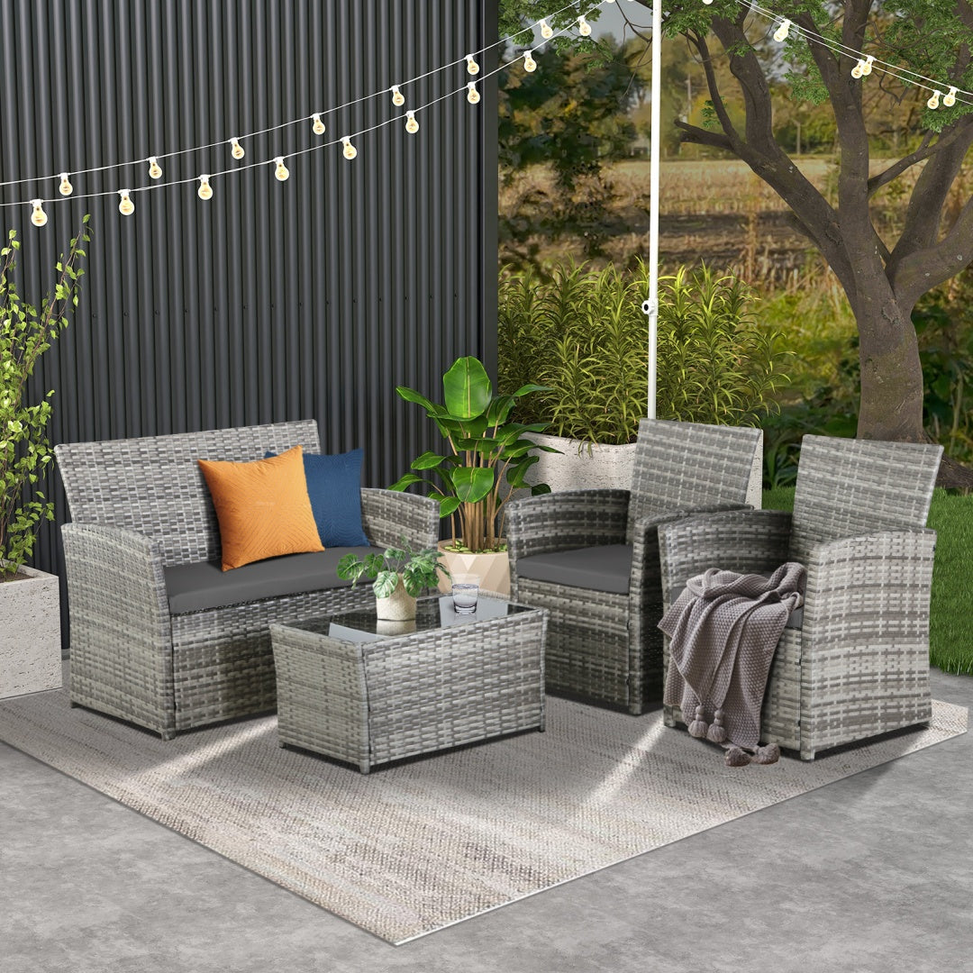 Four-piece rattan conversation set on a patio at dusk