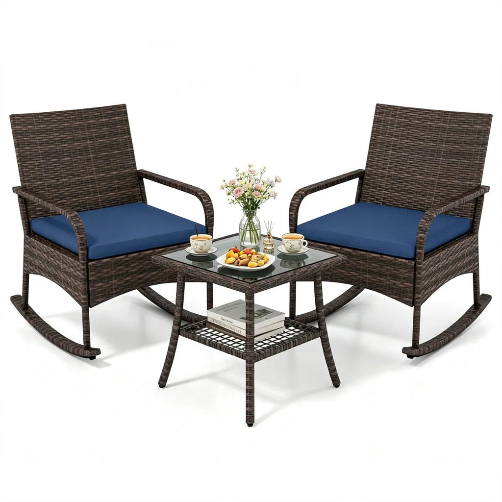 Three-piece brown wicker rocking chair set with navy cushions and two-tier glass side table
