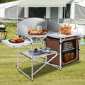 Folding camp kitchen set up outdoors with storage shelves