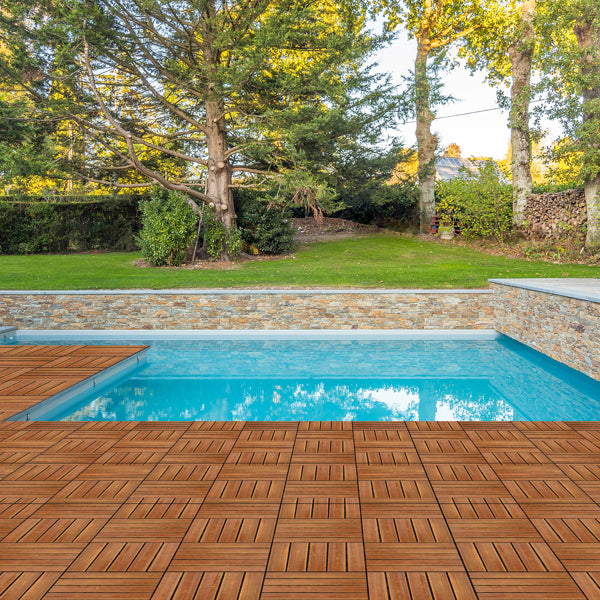 The tiles laid as a surround for a swimming pool, with lawn and trees beyond