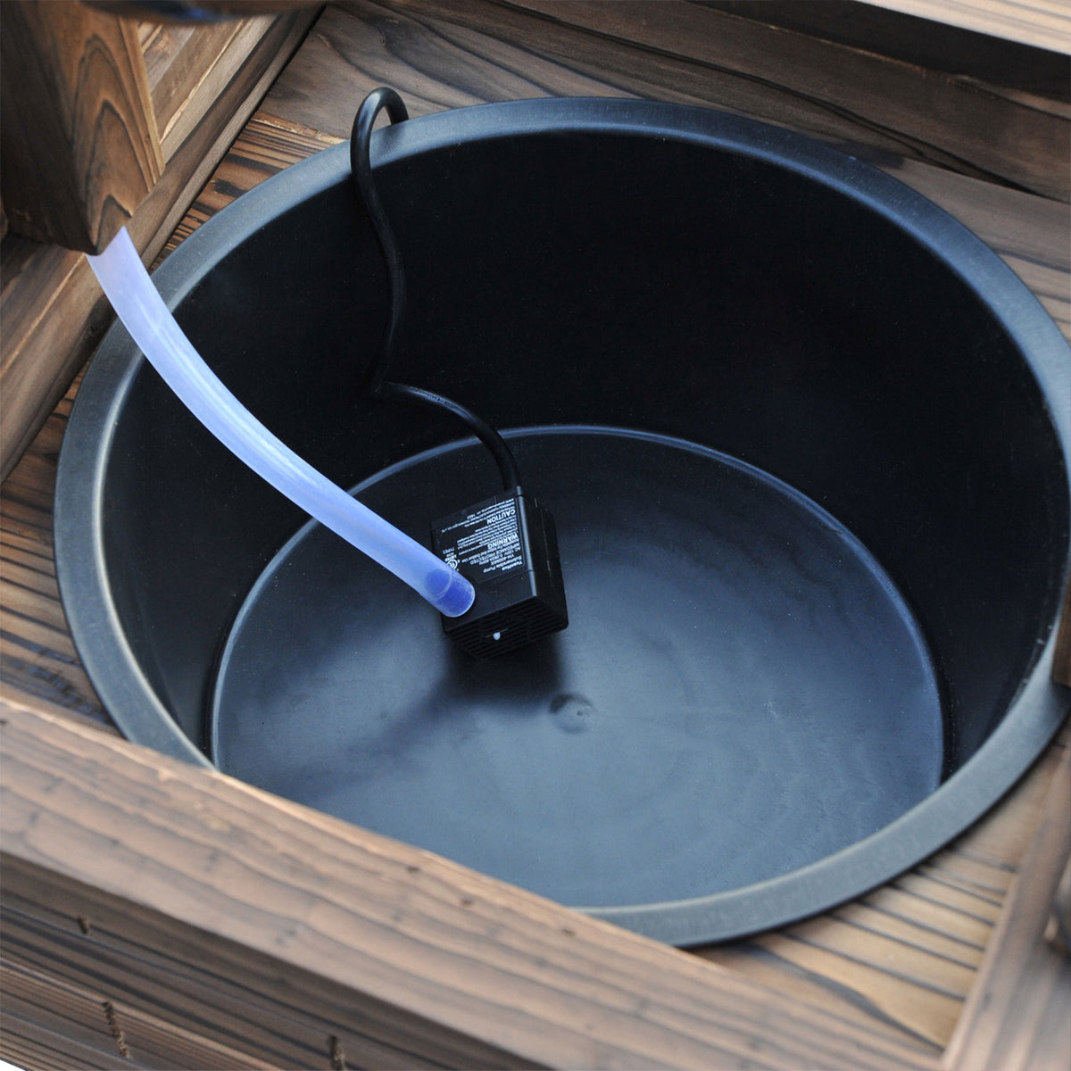 Lined basin inside the well box with the pump outlet