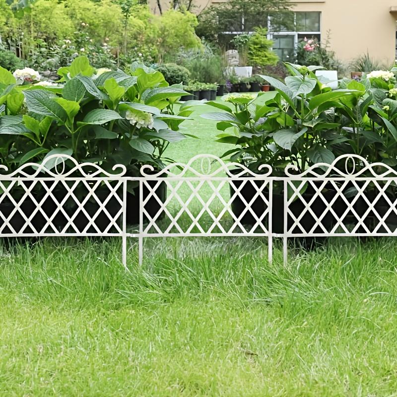White decorative fence bordering a planted bed