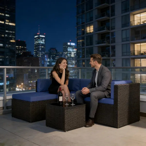 Navy-cushioned wicker sectional on a city terrace at night