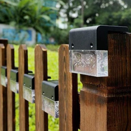 The light clipped to a garden fence post in daylight, solar panel facing up
