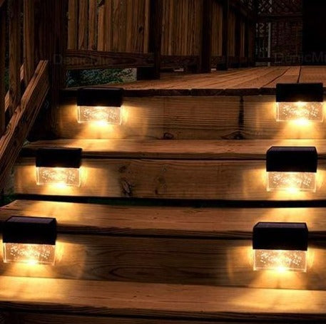 Warm white lights washing down a flight of wooden garden steps